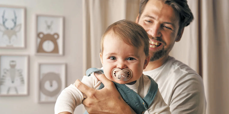 Bebé con chupete MAM Original en brazos de su papá