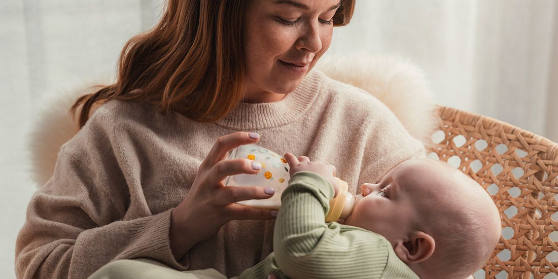 Mamá alimentando a su bebé con la mamadera de vidrio MAM Feel Good
