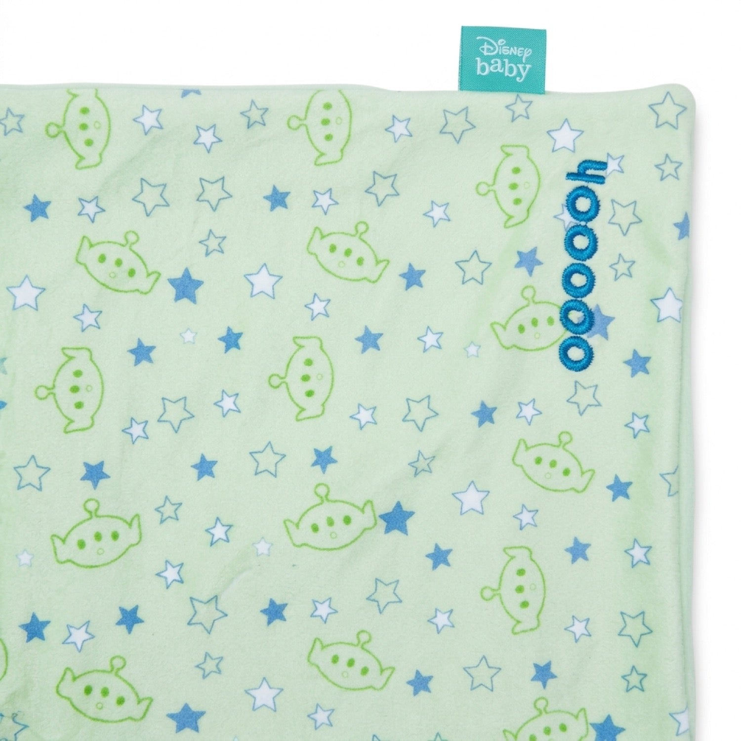 Detalle del estampado de aliens y estrellas, el bordado oooooh y la etiqueta oficial Disney baby