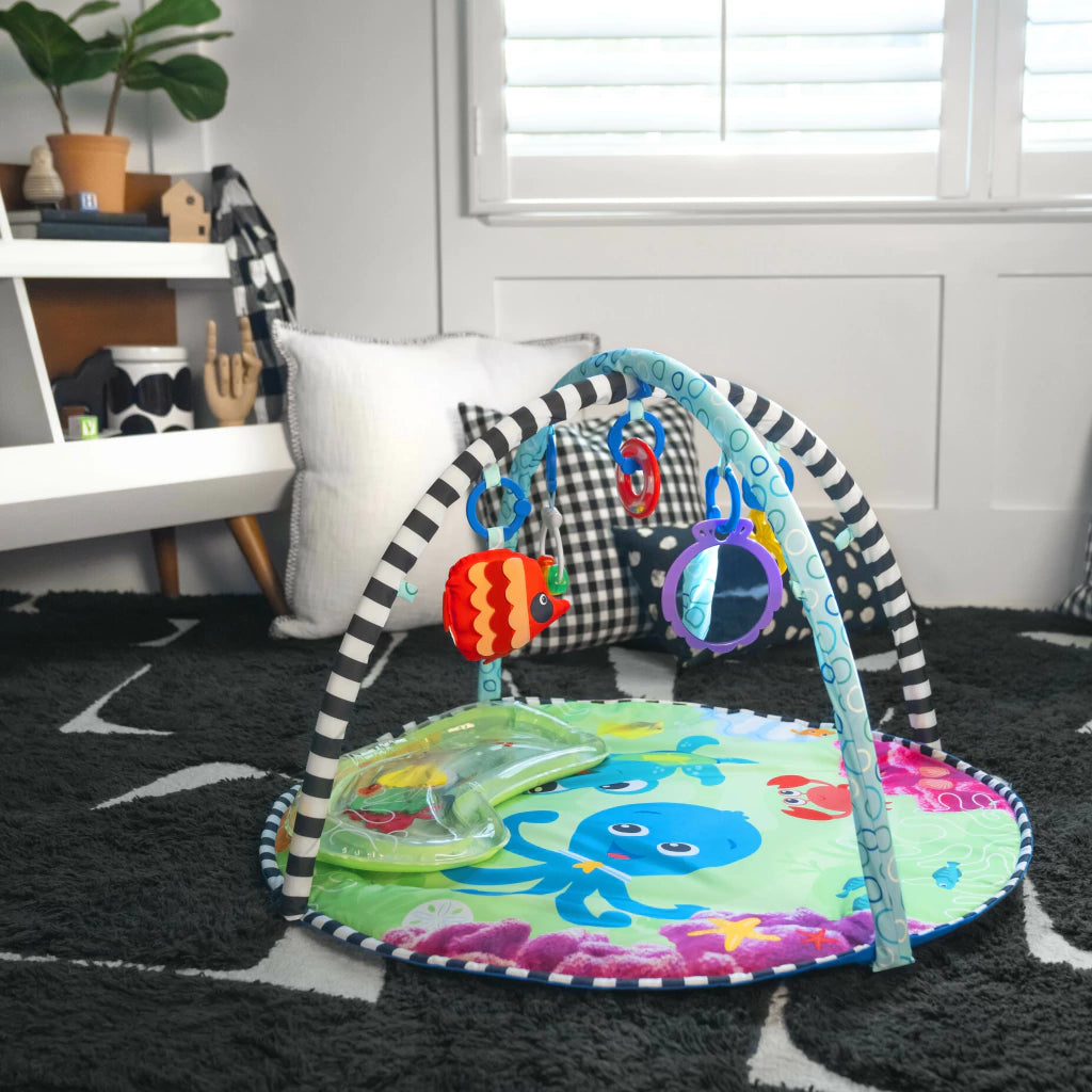 Bebé jugando con el tapete acuático Baby Einstein