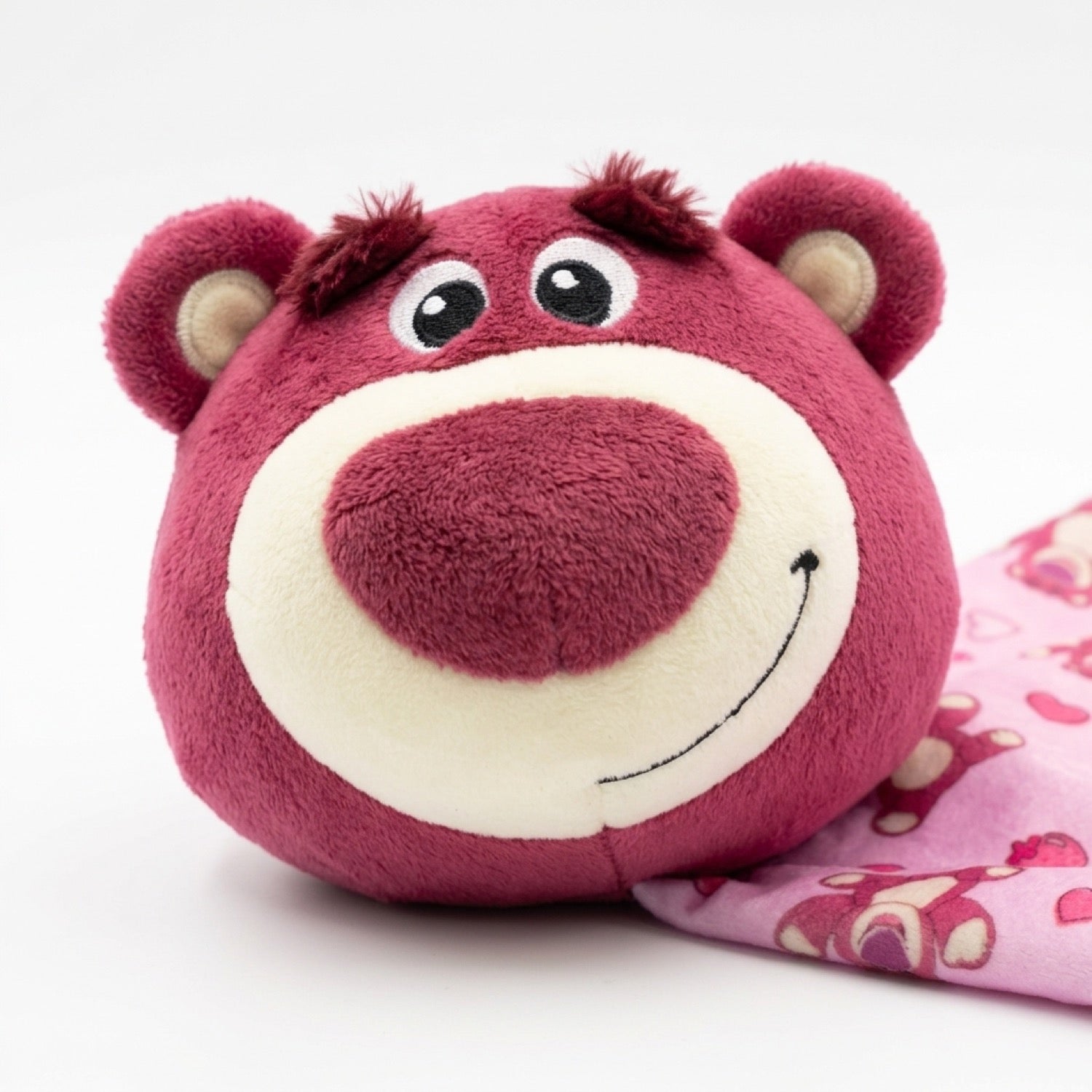 Primer plano de la carita de peluche de Lotso, suave y sonriente