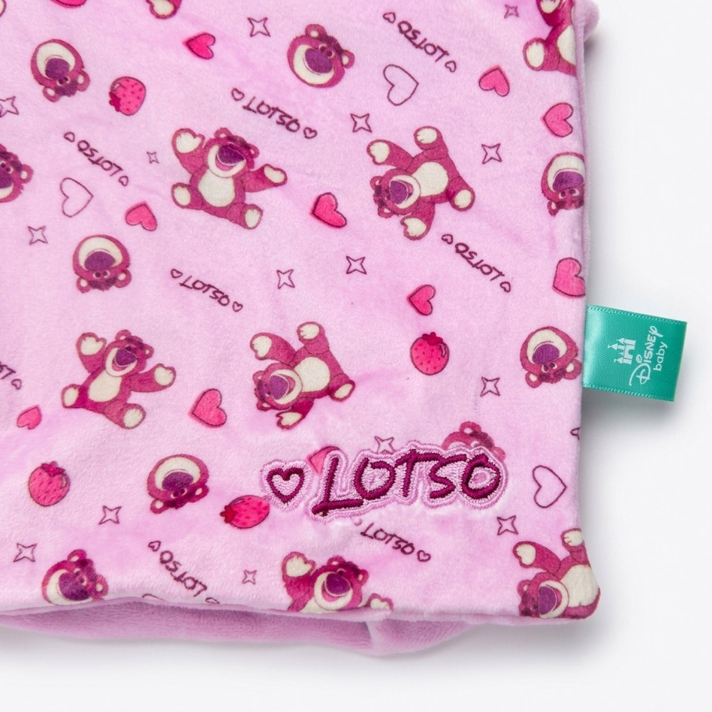 Detalle del estampado Lotso, el parche bordado y la etiqueta oficial Disney baby
