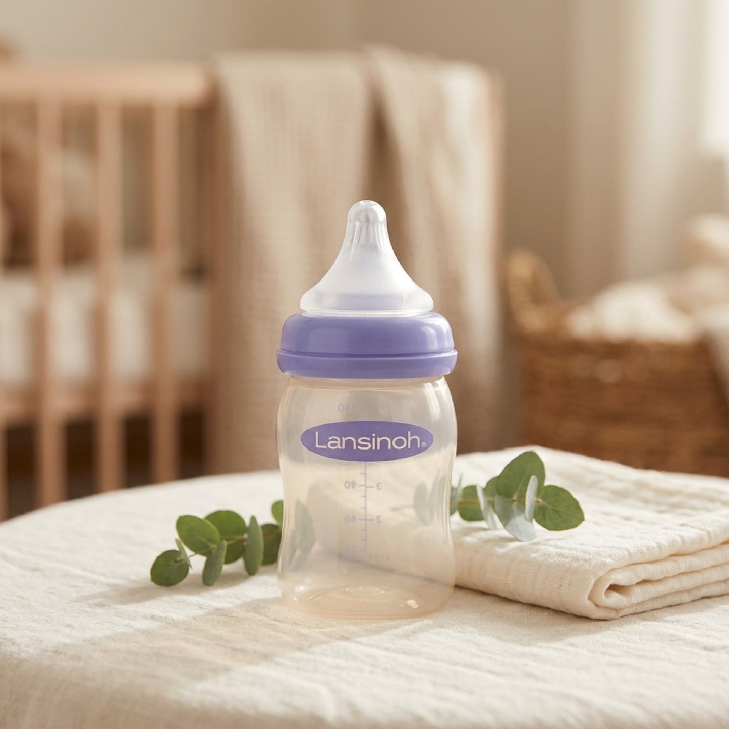 Mamadera Lansinoh Natural Wave sobre textil suave en ambiente de dormitorio